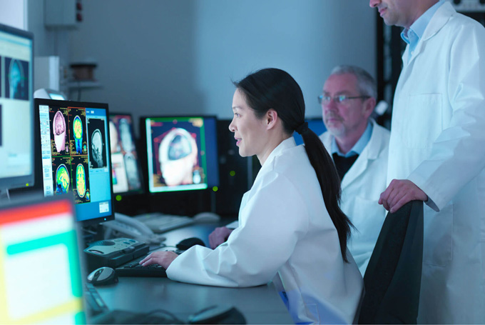 A woman and a man look at data on a computer screen