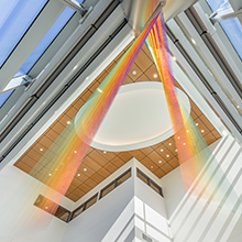 Streaks of rainbow colored materials draped from the cieiling of an atrium.